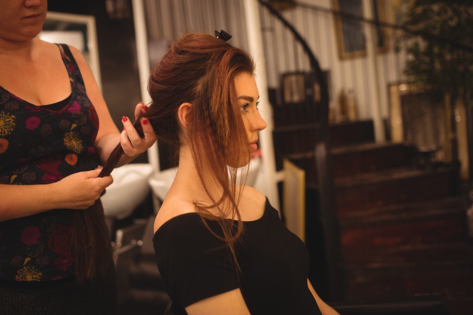 Beautiful woman styling her hair at saloon